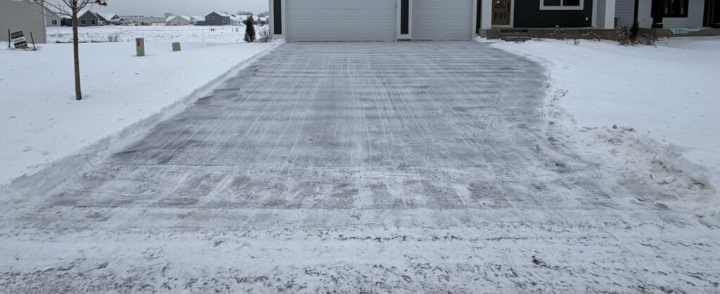 Residential driveway cleared of snow by Land of 10,000 Lawns